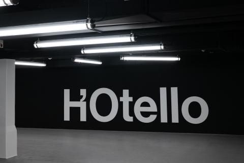 Underground parking garage of hotel in Schwabing with black and white logo on wall