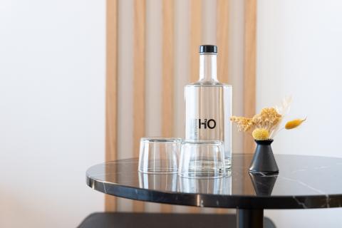 Black marble table with water bottle, glasses and decorative flowers